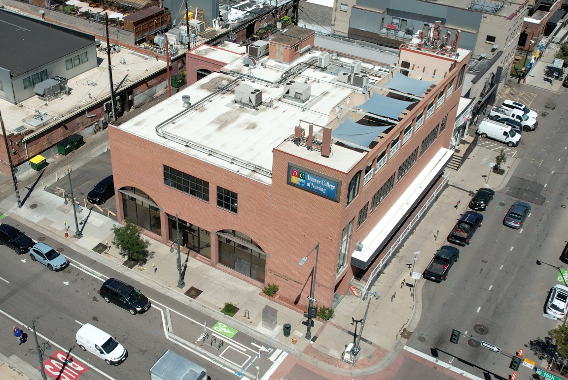 Aerial view of brick college building on city street corner