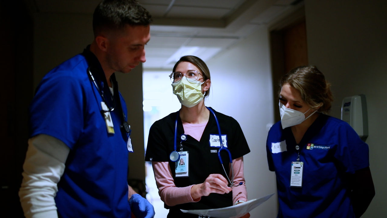 Medical professionals discussing patient care in hallway